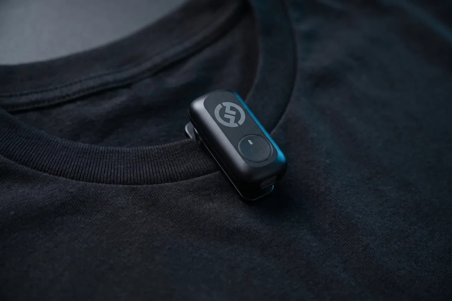 Hollyland LARK A1 transmitter clipped to the collar of a black T-shirt