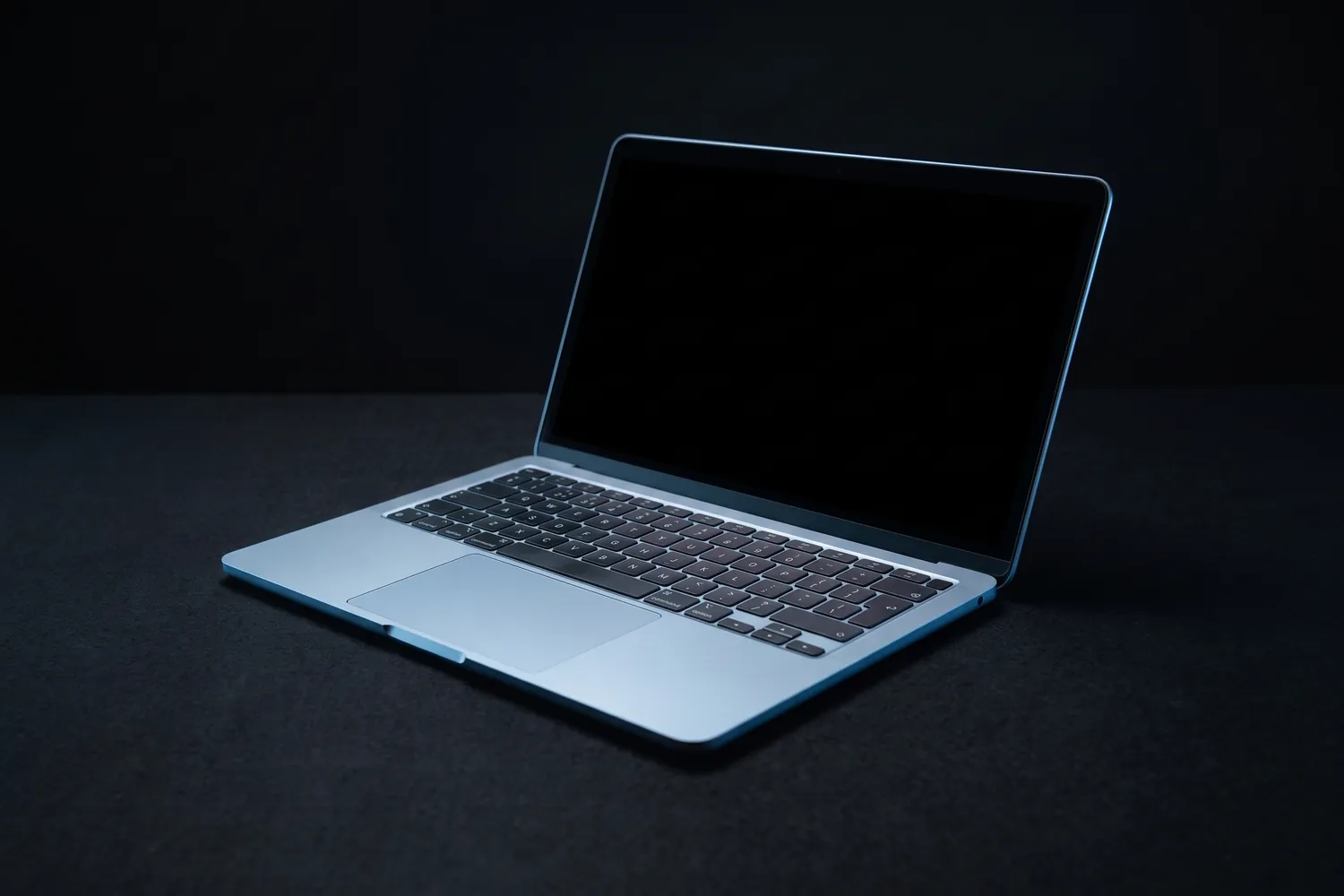 Apple MacBook Air 13-inch, half open on a dark surface