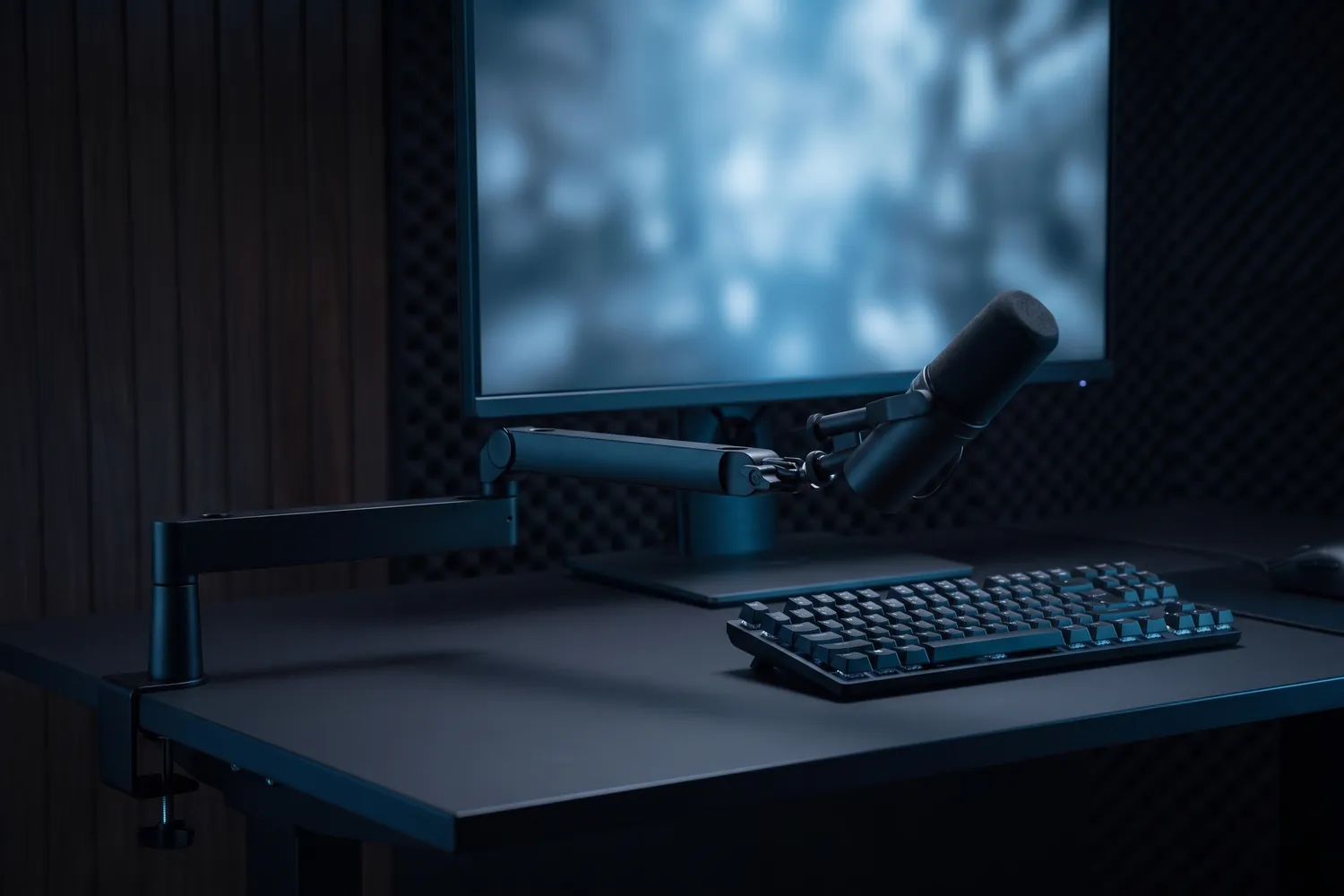 Elgato Wave Mic Arm LP reaching in below a monitor on a streaming desk