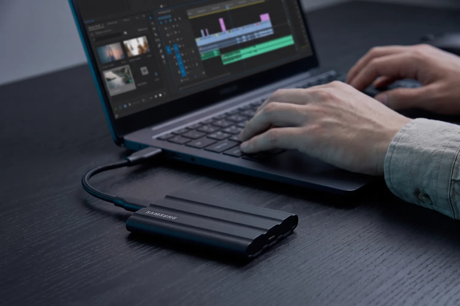 Samsung T7 Shield connected to a laptop while someone edits video