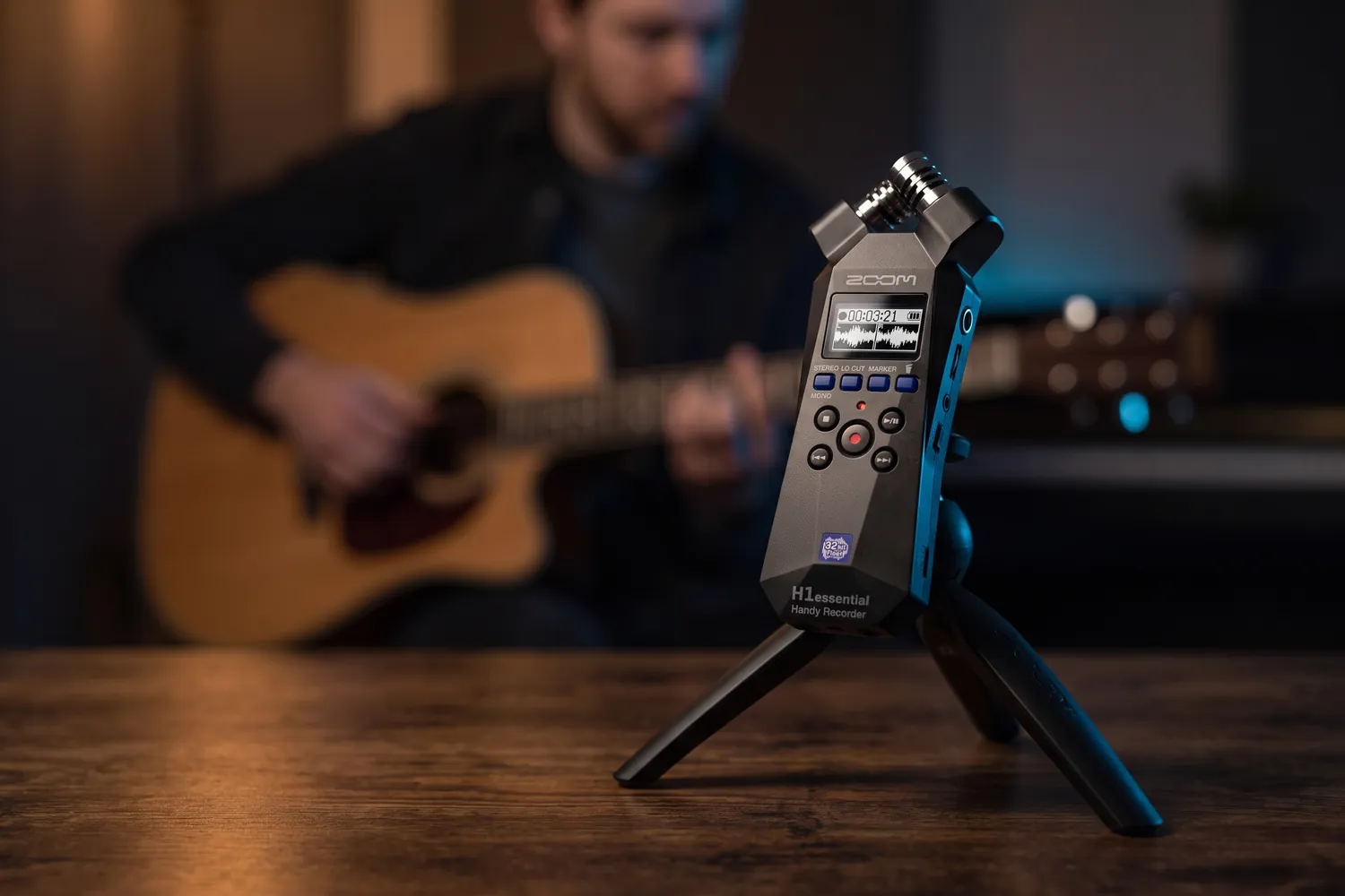 Zoom H1essential on a small tripod, recording a guitarist