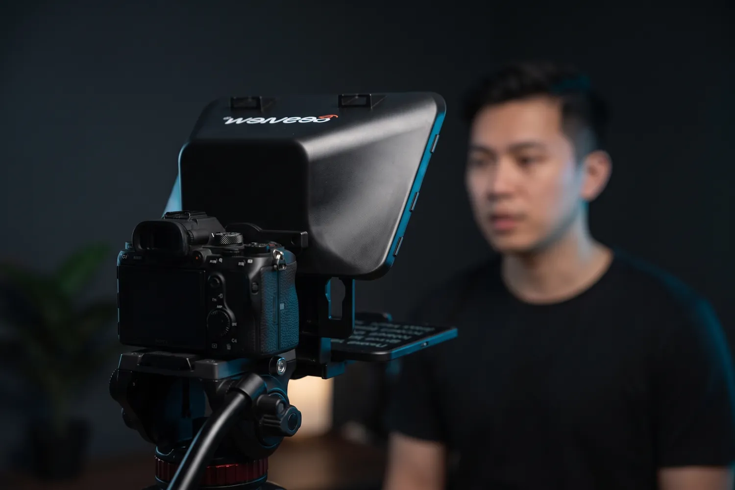 Desview T3 on a camera, a creator reading from it in a home studio